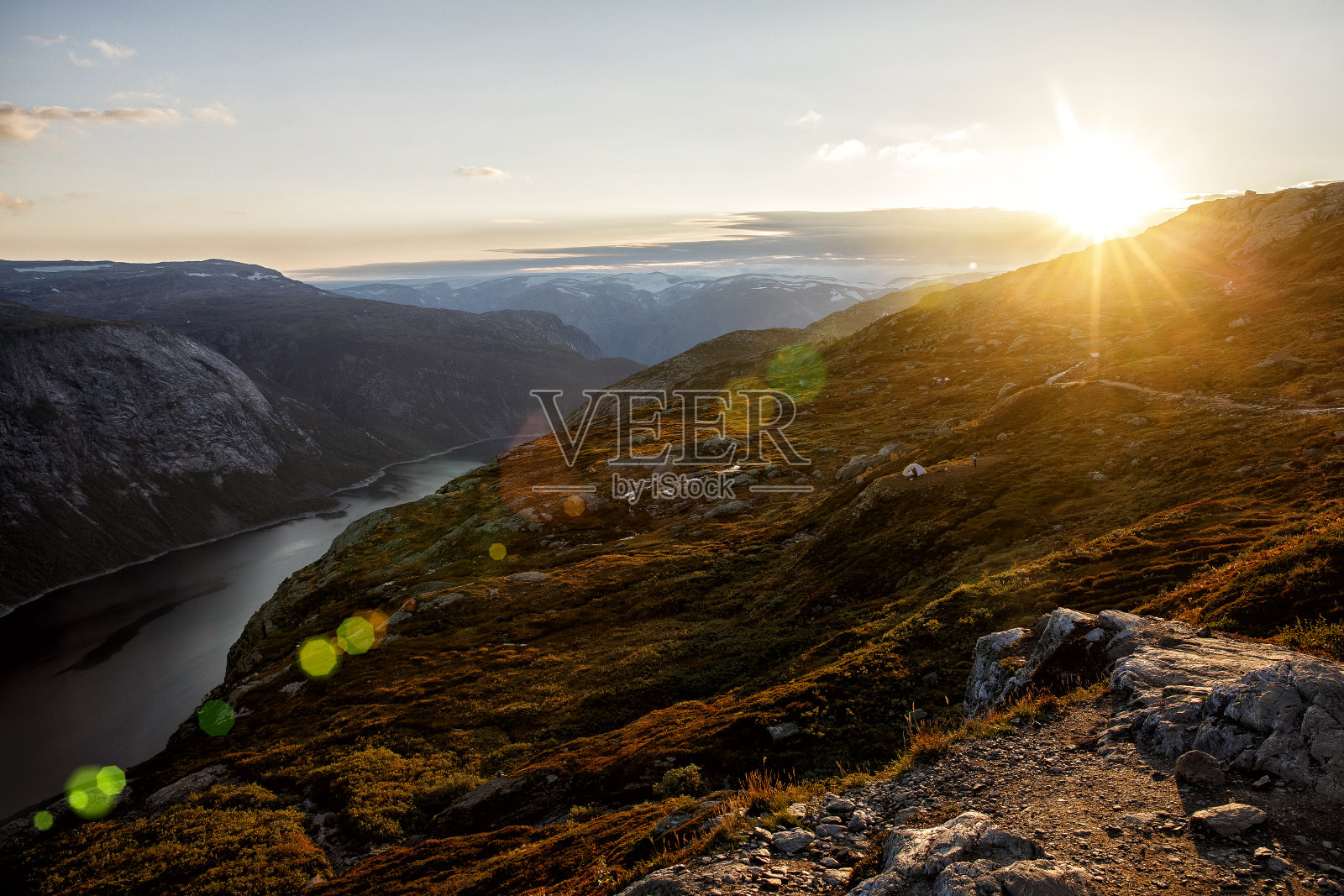 挪威山上的日落。峡湾上的橙色灯光。照片摄影图片