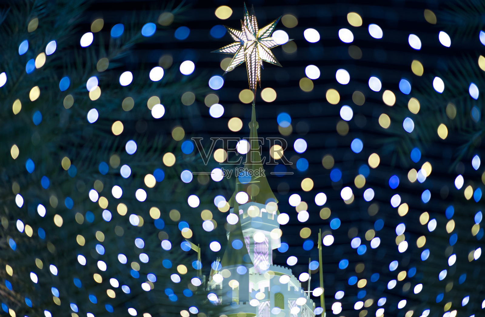 城堡顶部有一个星星标志的城堡,晚上有美丽的彩色散景图案照片摄影图片