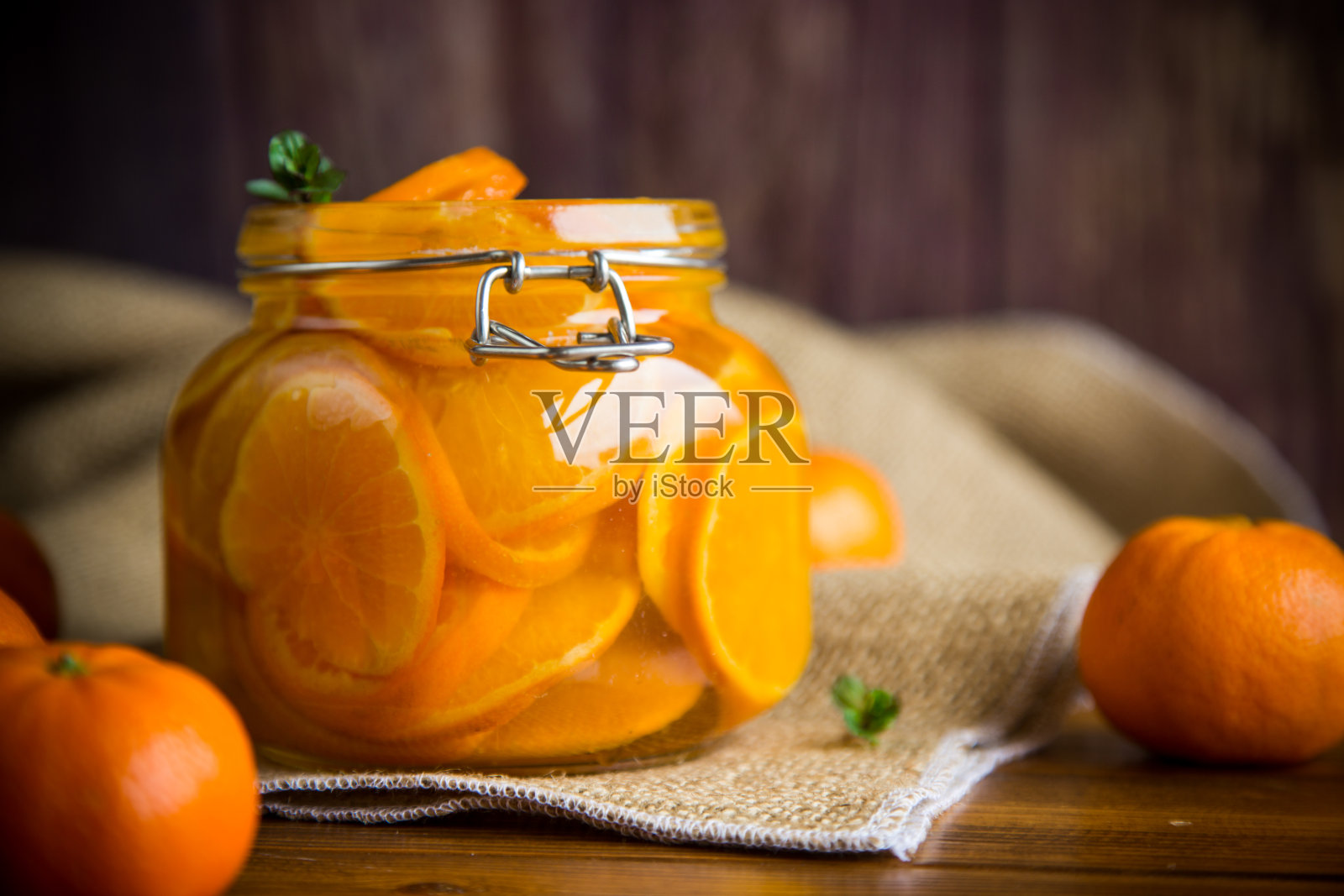 橘子酱装在一个玻璃罐里,放在一张木桌上照片摄影图片