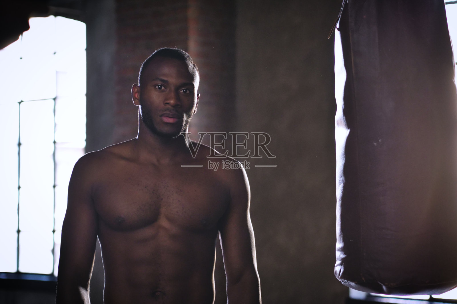 一个汗流浃背、肌肉发达的男人在刚刚完成的艰苦工作中艰难呼吸的肖像。照片摄影图片