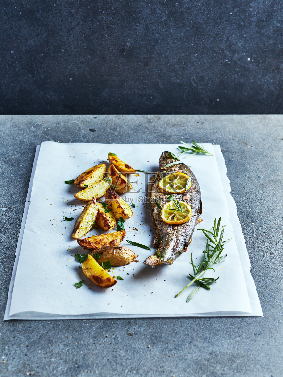 烤鳟鱼配烤土豆和香草。乡村自制的食物照片摄影图片