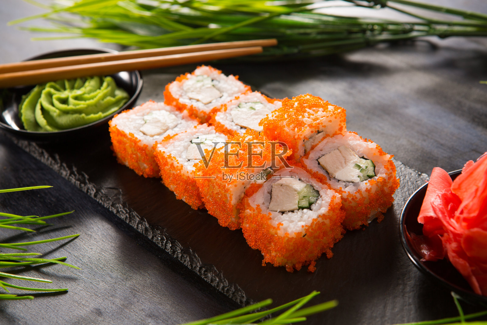 一套寿司卷与芥末和生姜在黑色的背景。日本东方美食照片摄影图片