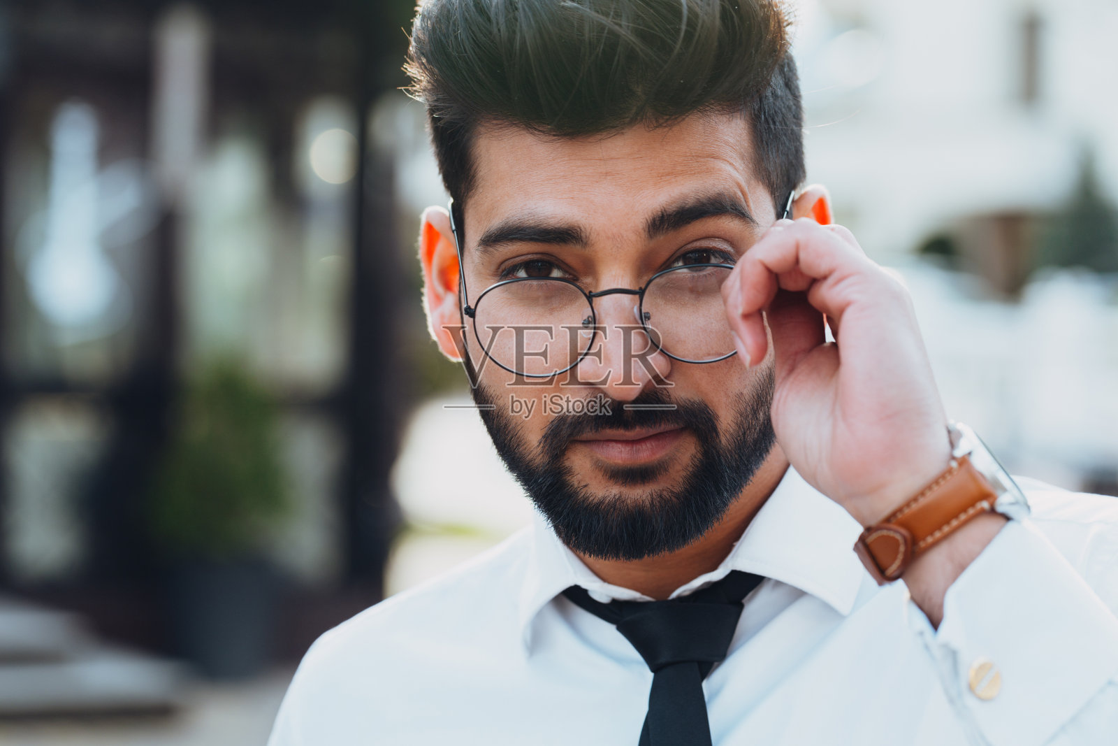 穿着时髦的印度胡子男子走在街上。照片摄影图片