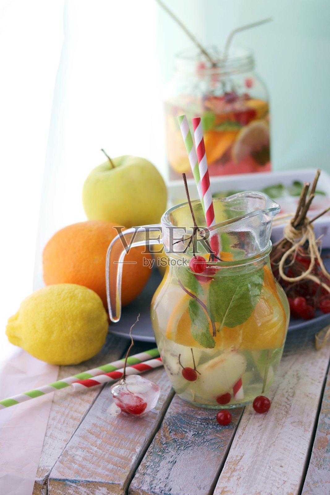 清新的鸡尾酒,有机水果和浆果的排毒水,放在木桌上的玻璃罐里的薄荷叶照片摄影图片