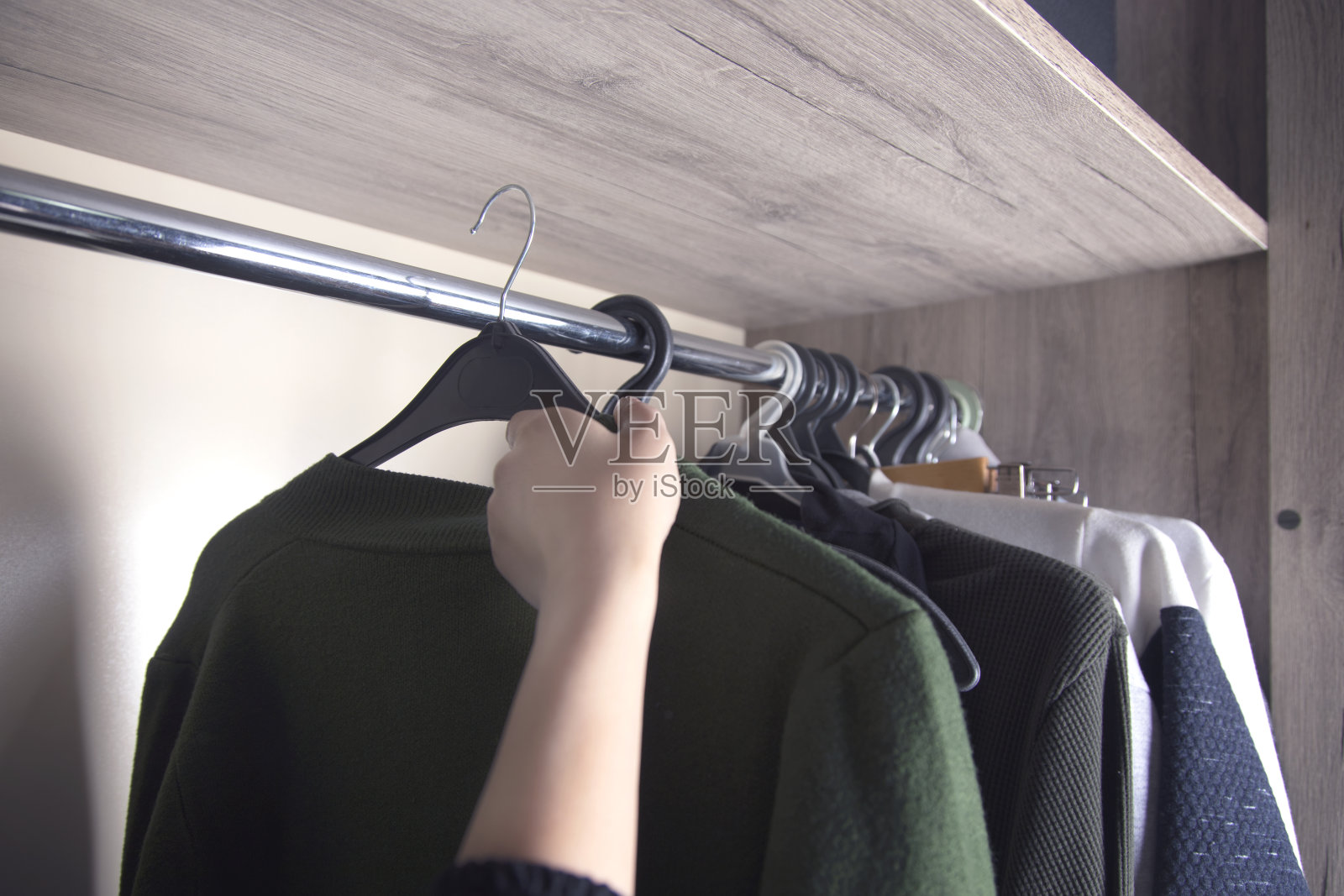 女人从衣橱里挑选衣服照片摄影图片