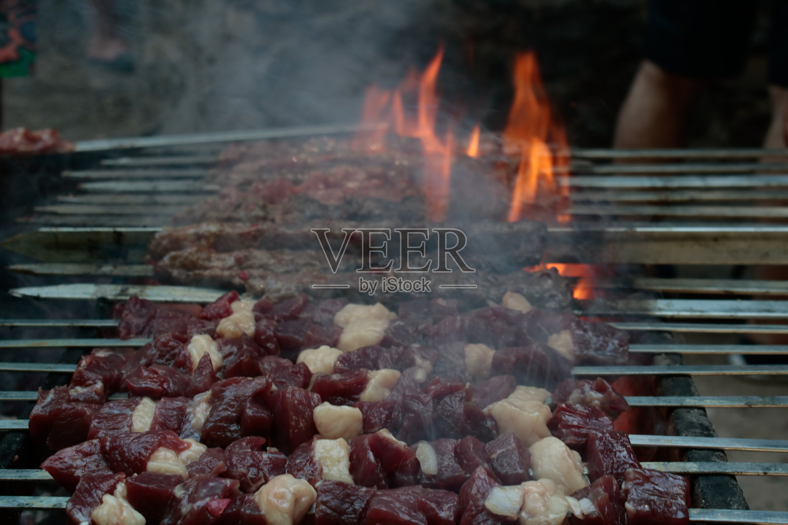肥肉串在串上。它看起来烟熏的,燃烧的,美味的。照片摄影图片