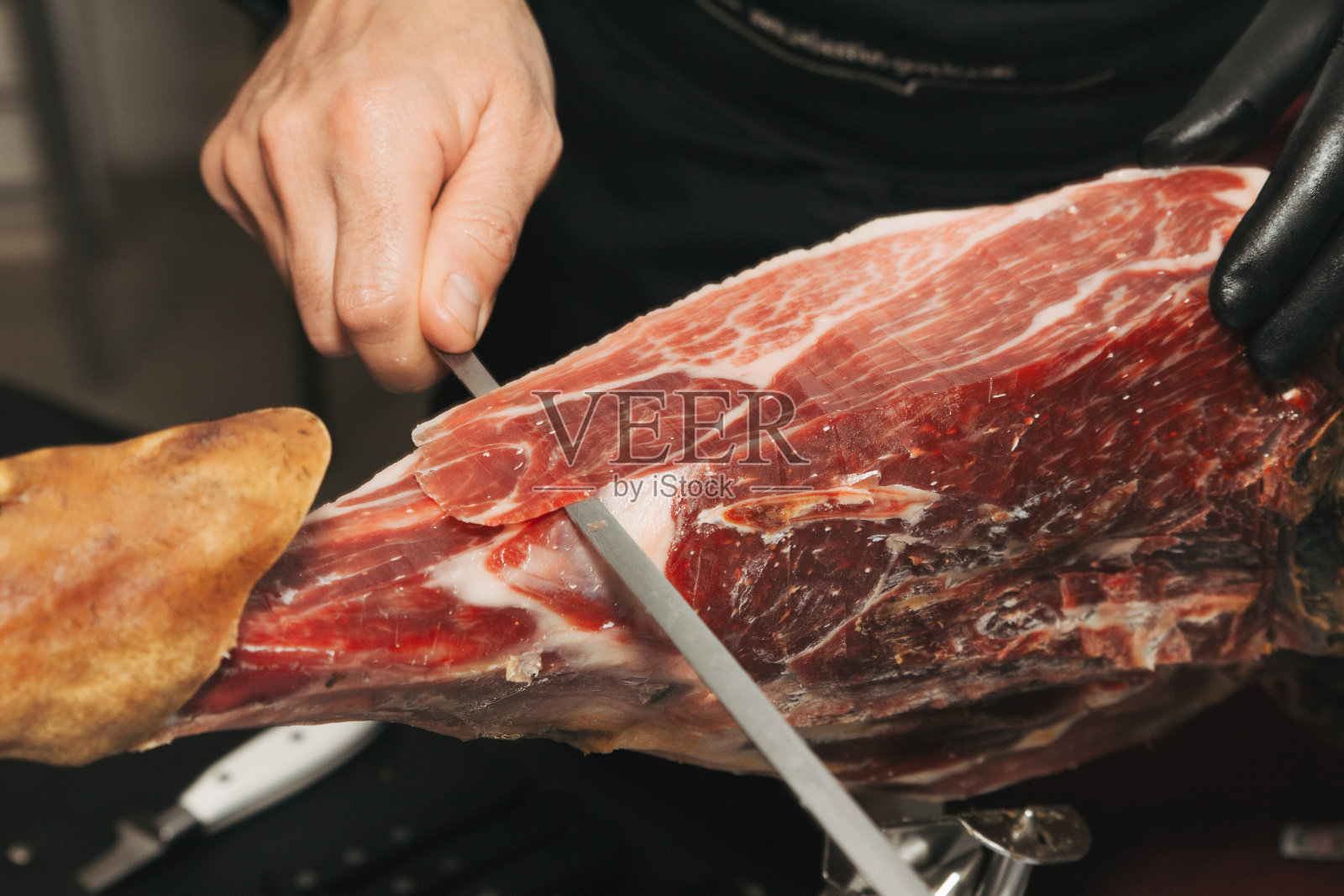 一个伊比利亚火腿切刀大师的手的库存照片。切割伊比利亚火腿照片摄影图片