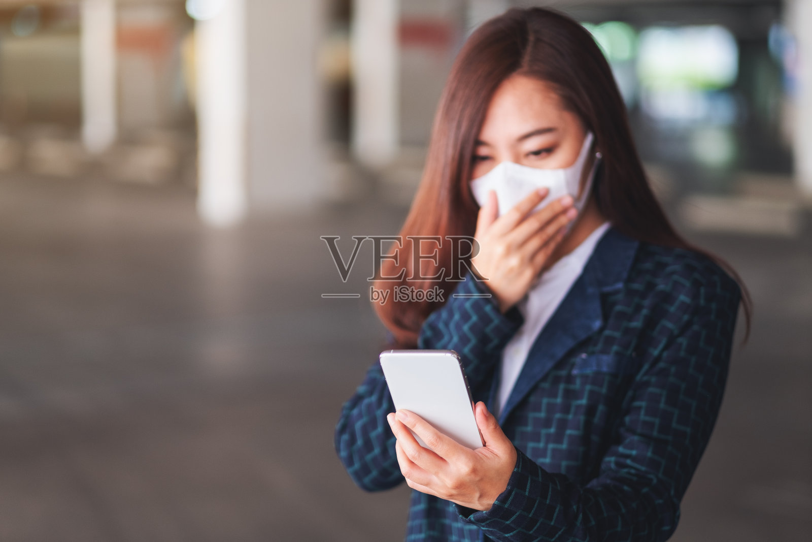 戴防护口罩的生病女人使用手机,用于医疗保健和新冠病毒概念照片摄影图片