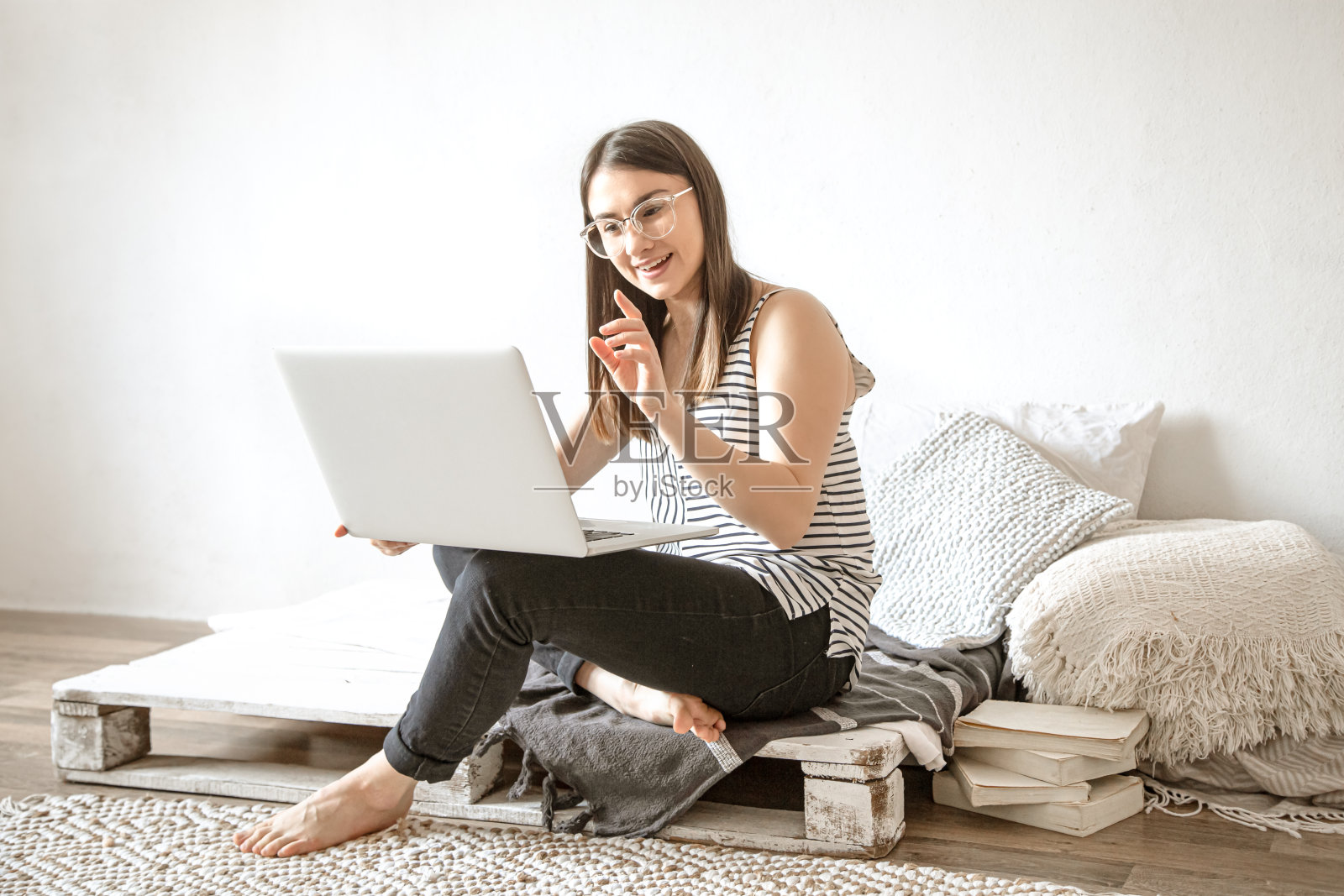 一位年轻女子在家通过电脑远程工作。照片摄影图片