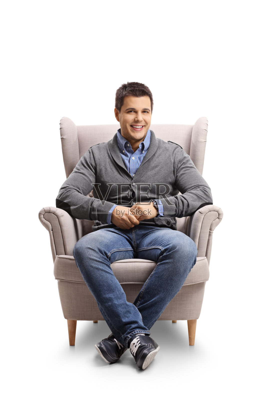 微笑的年轻人坐在扶手椅上照片摄影图片
