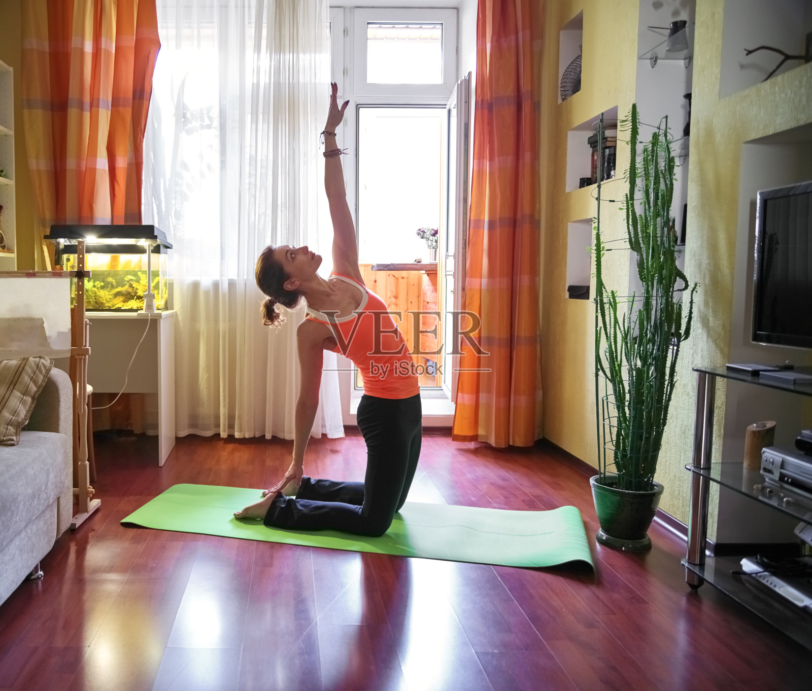 年轻女子在客厅练习瑜伽照片摄影图片