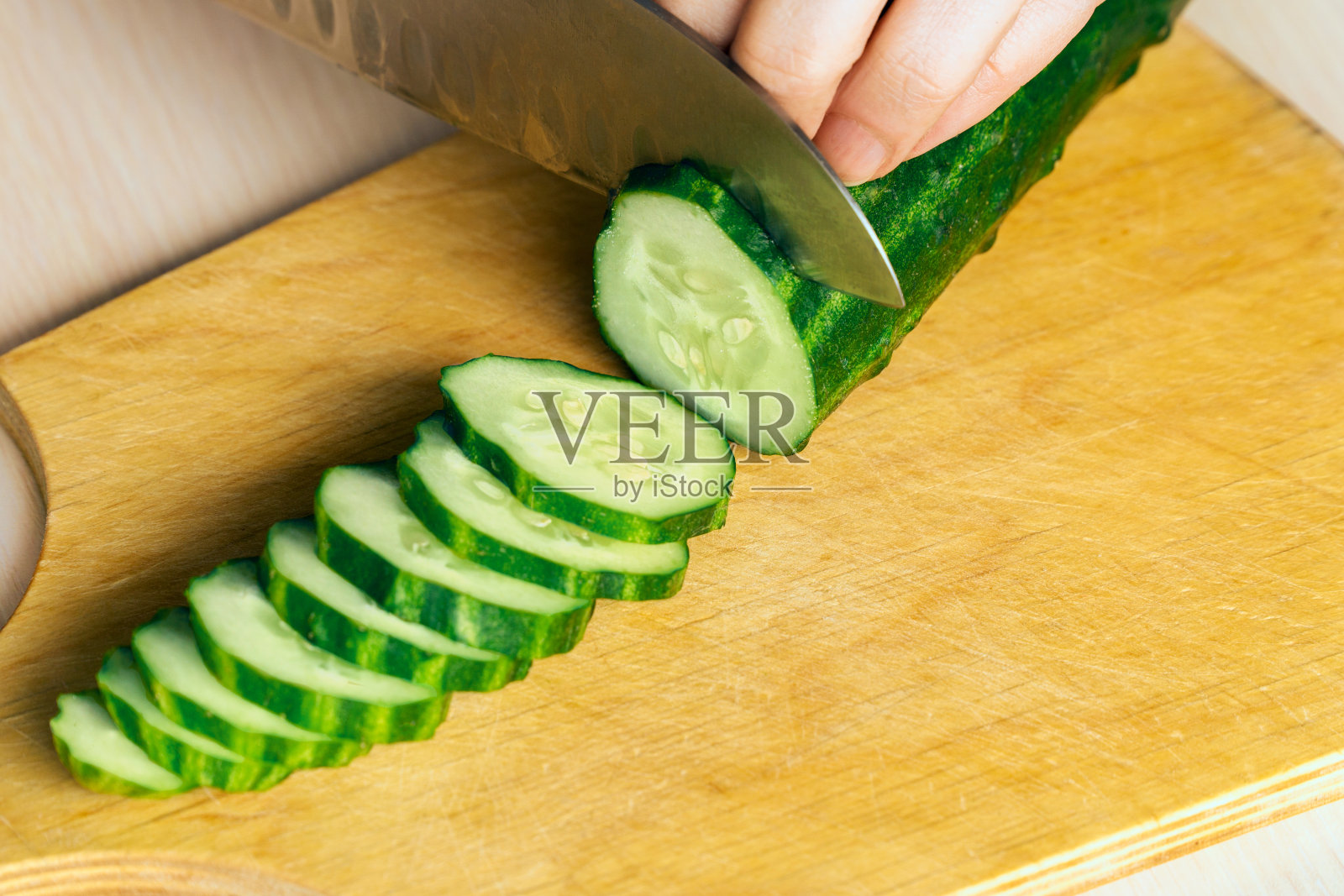 在一块有纹理的旧木板上切黄瓜照片摄影图片