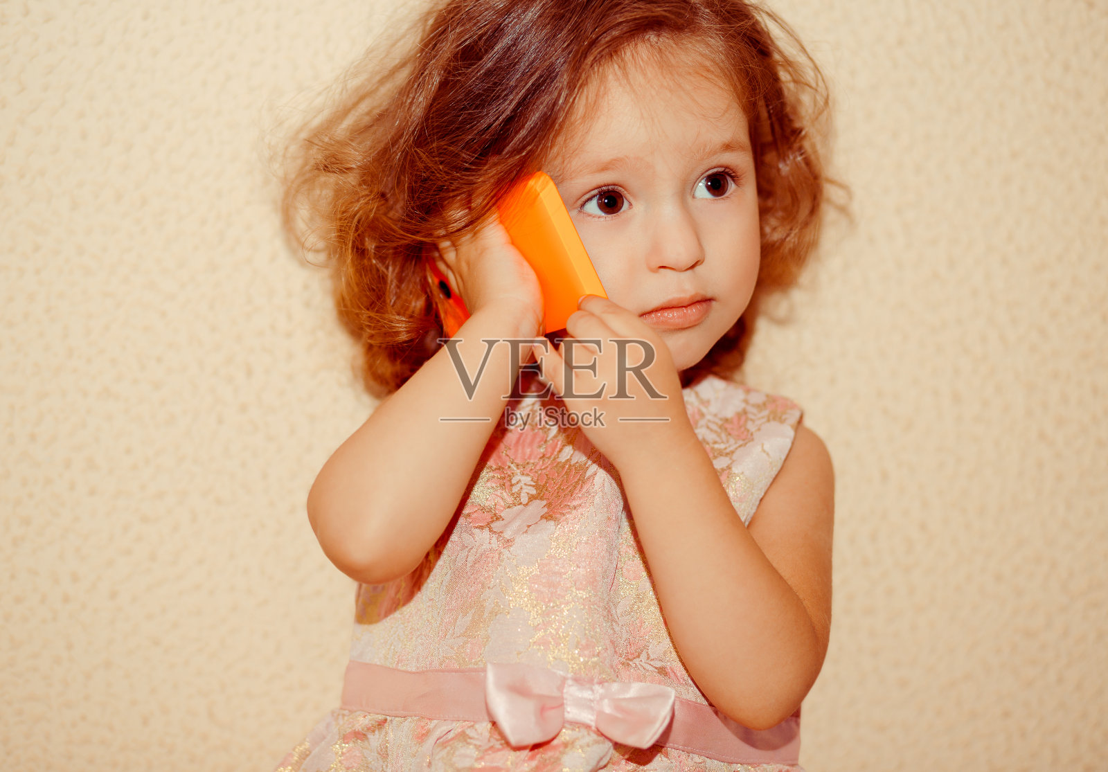 一个惊讶的小女孩的肖像与手机孤立在白色的背景照片摄影图片