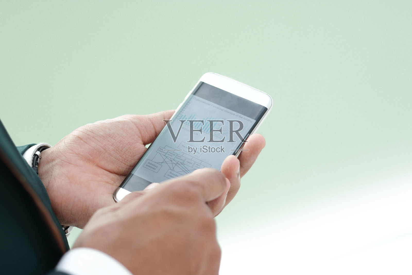 关闭了。一个商人在看智能手机上的短信。照片摄影图片