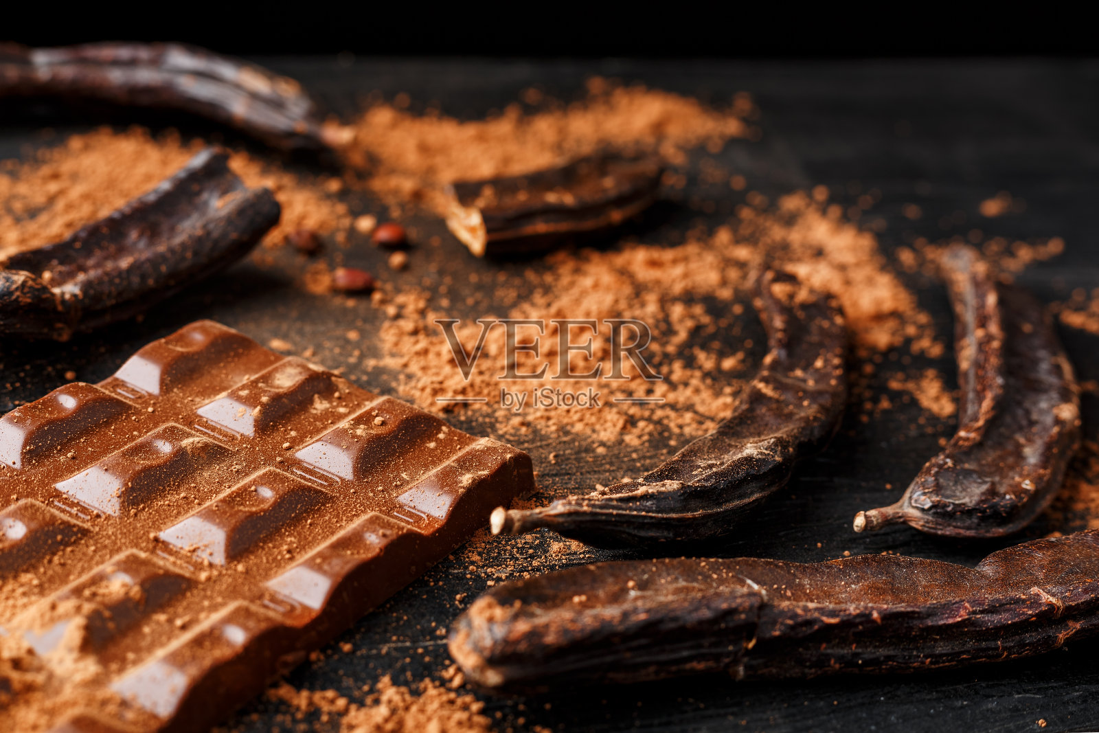 黑背景上的角豆巧克力豆荚。照片摄影图片