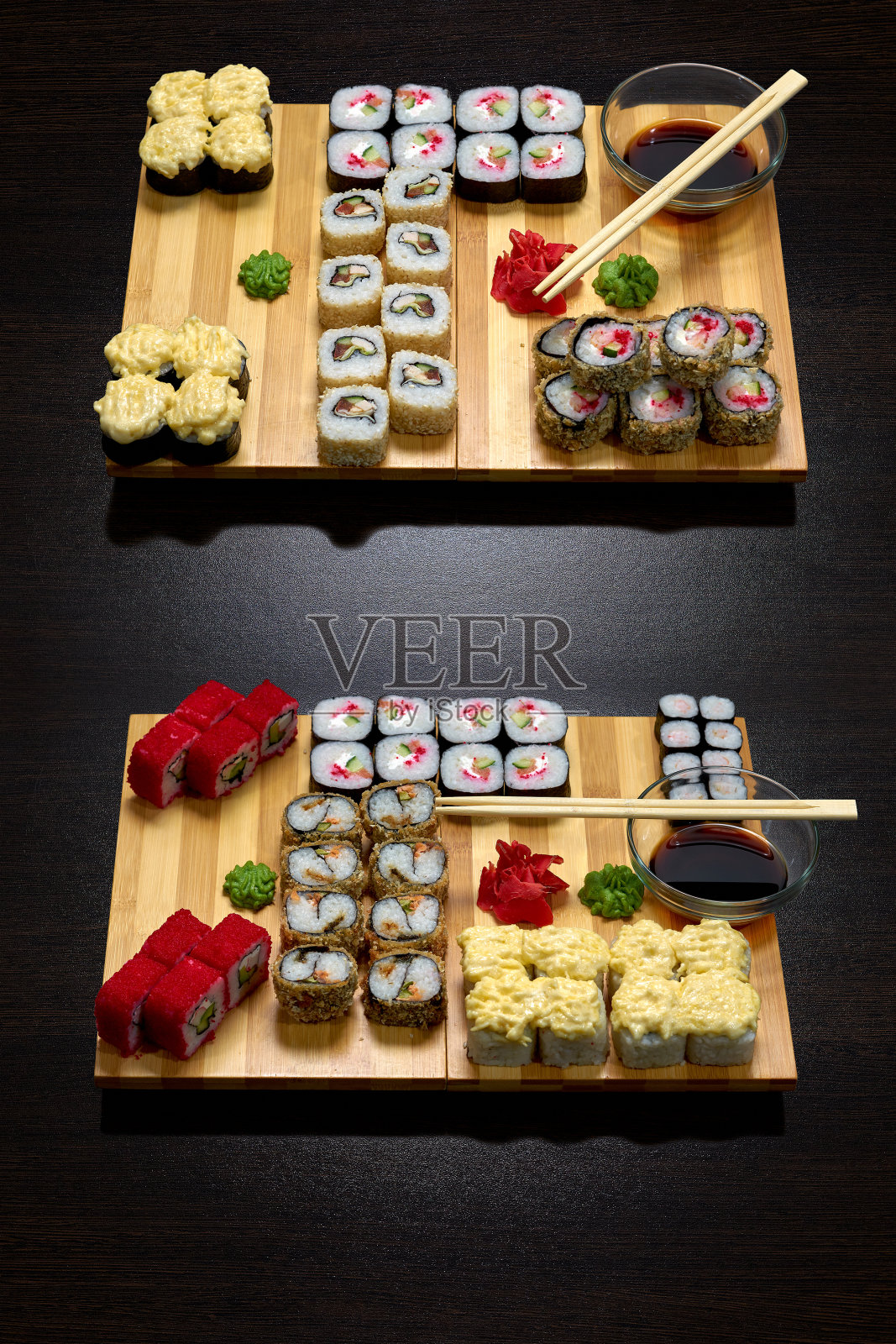 美味的冷热寿司卷在黑板上的黑暗背景。照片摄影图片