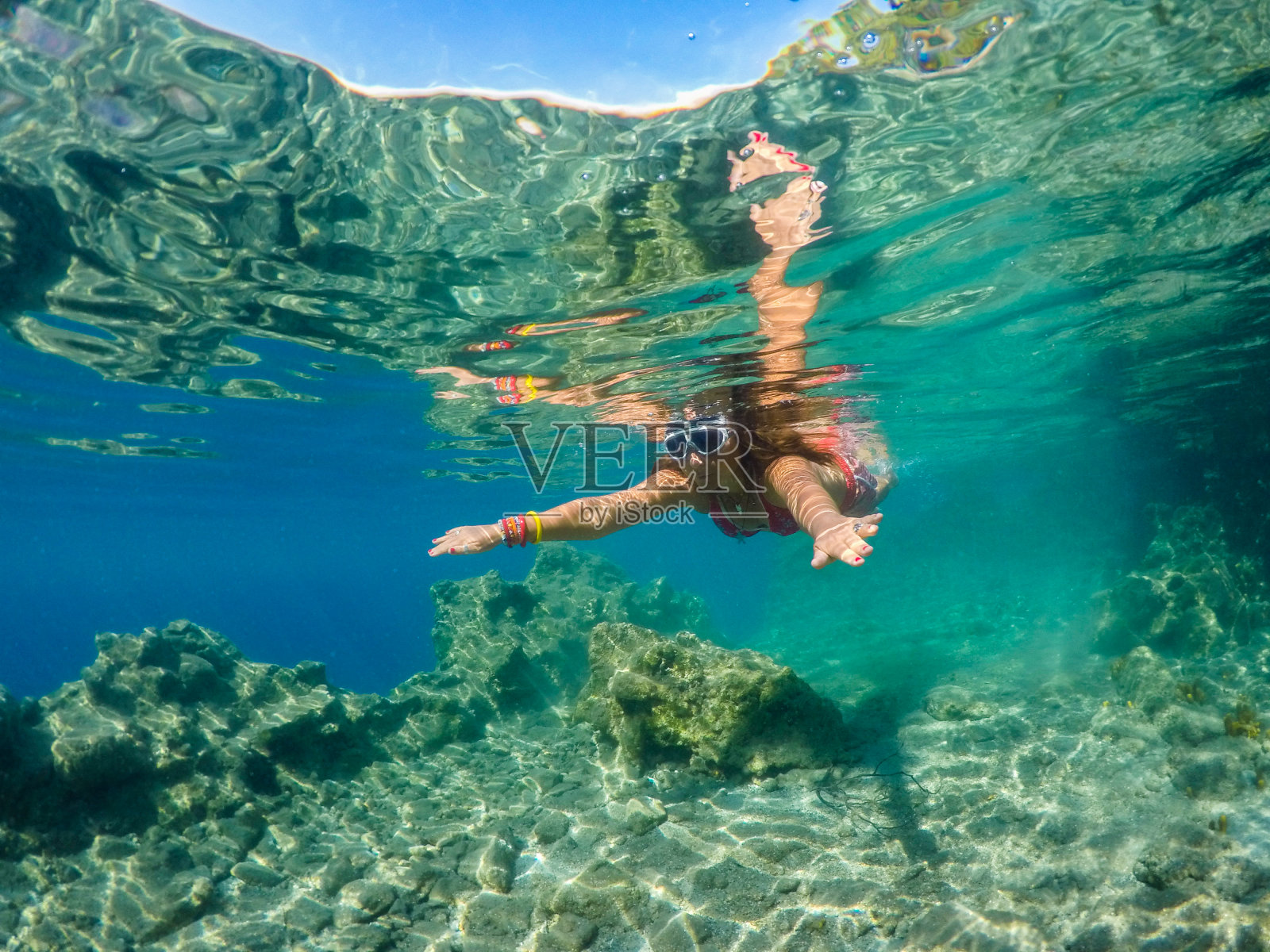 女人漂浮在干净的大海里。照片摄影图片