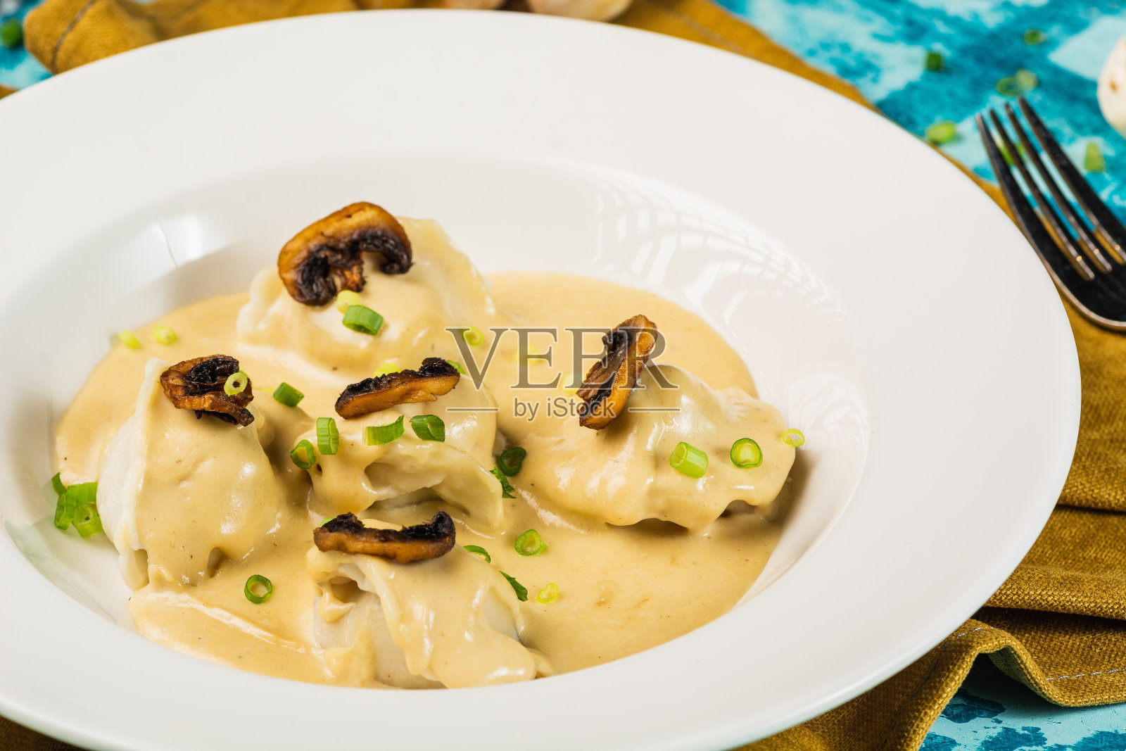 蘑菇和奶油酱意大利饺子。自制意大利传统食物。关闭了。配蘑菇和青葱照片摄影图片