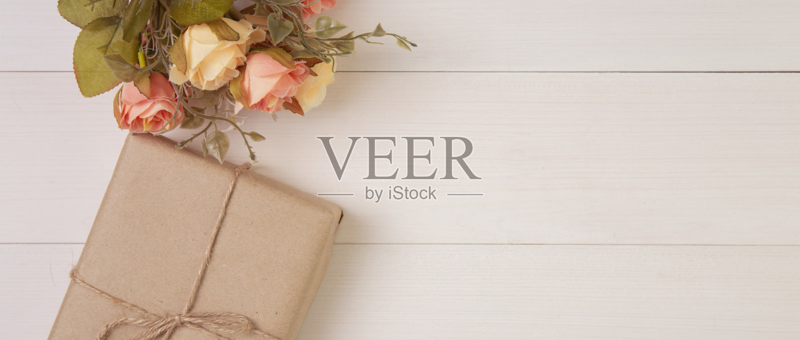 美丽的花和礼物盒在木制的背景与浪漫,母亲节或情人节的礼物与柔和的色调,办公桌上的装饰,假日概念,横幅网站。照片摄影图片