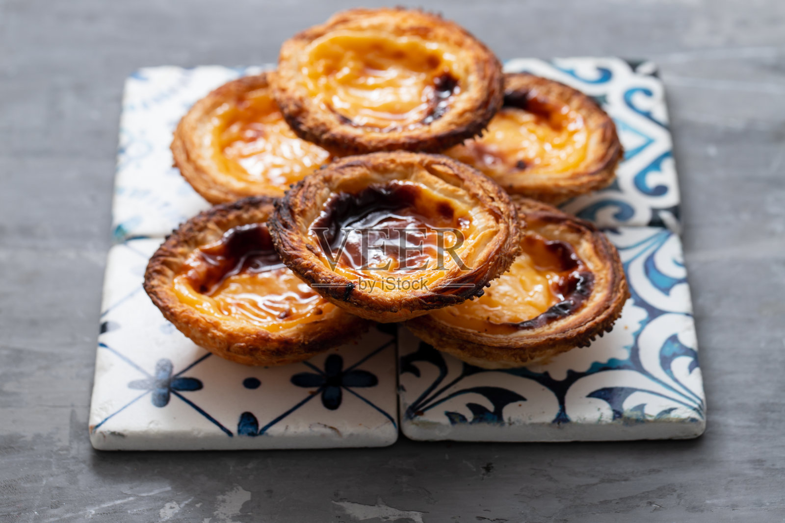 典型的葡萄牙蛋挞粉彩在陶瓷背景上照片摄影图片