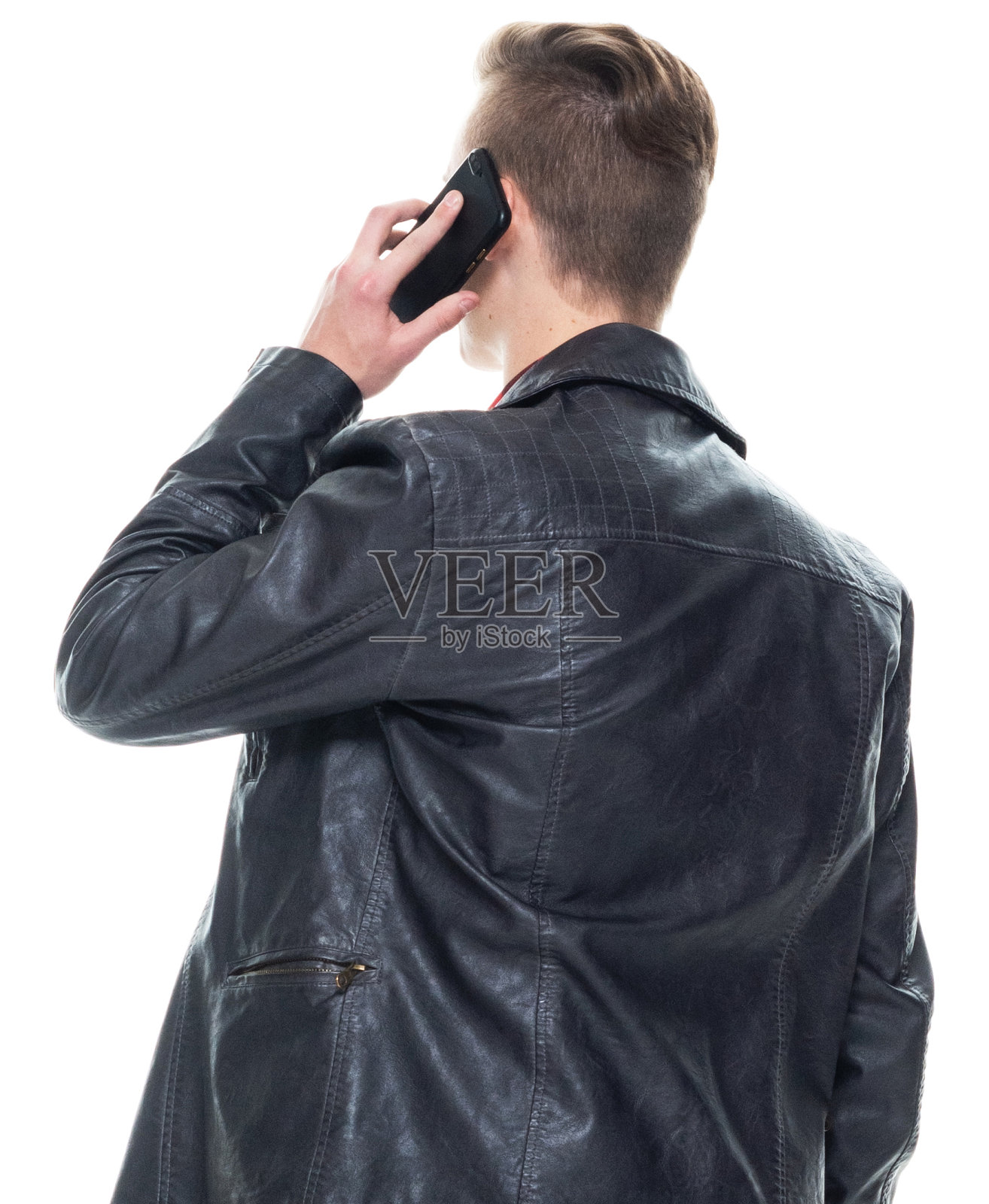 穿着皮夹克、使用智能手机的白人男孩站在白色背景前照片摄影图片