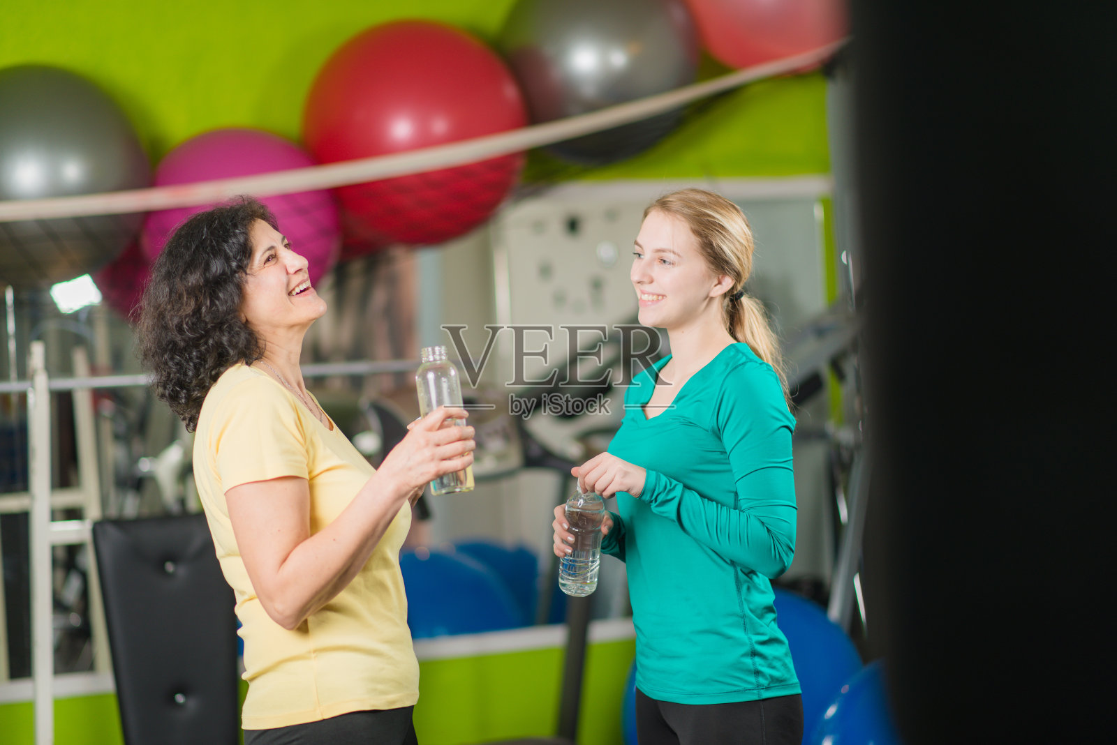 成熟的年轻女性在健身房锻炼和社交照片摄影图片