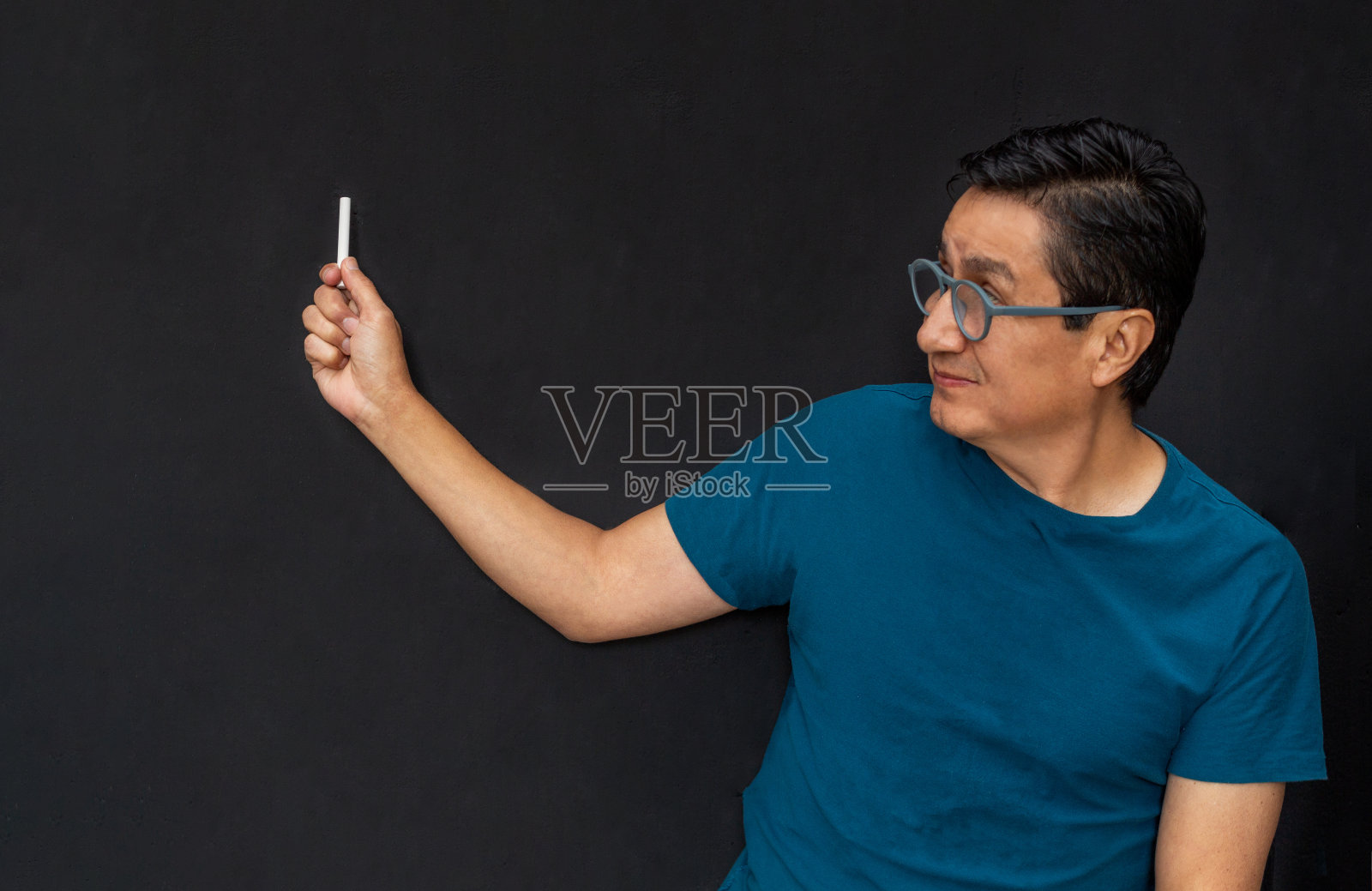 微笑的老师用粉笔在黑板上讲课照片摄影图片