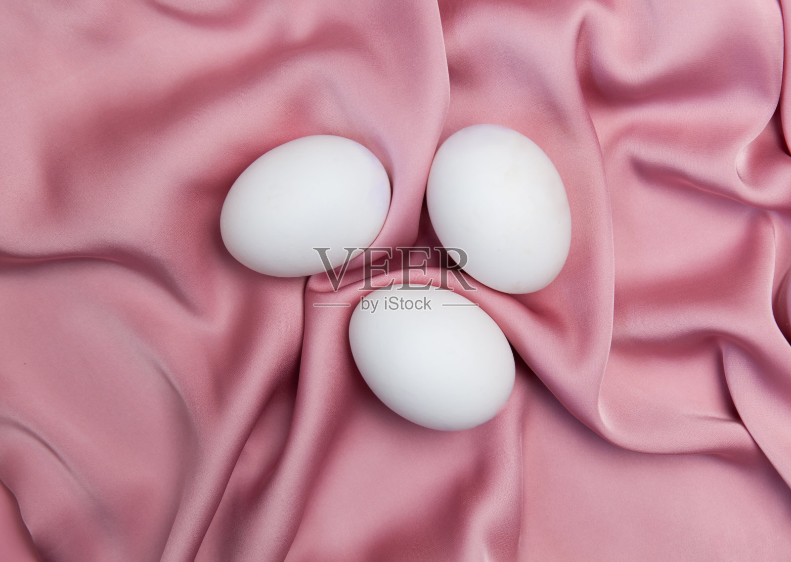 创造性的复活节米色和粉红色的背景与白色的鸡蛋。照片摄影图片