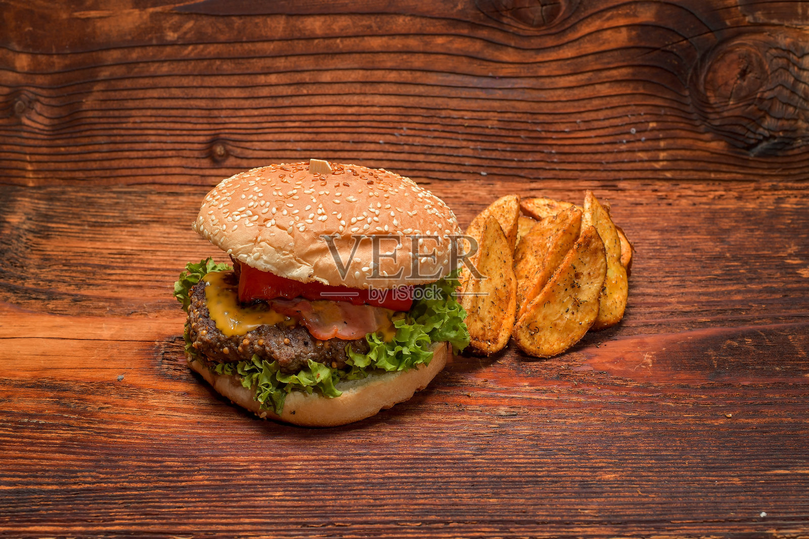 木托盘上放着汉堡和炸薯条。照片摄影图片