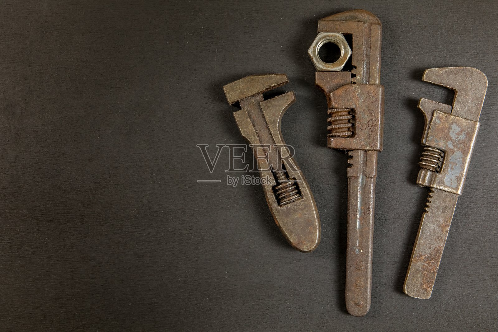 旧生锈的扳手上的黑色背景,俯视图。旧肮脏的工具。手工制作的。家庭维修。照片摄影图片