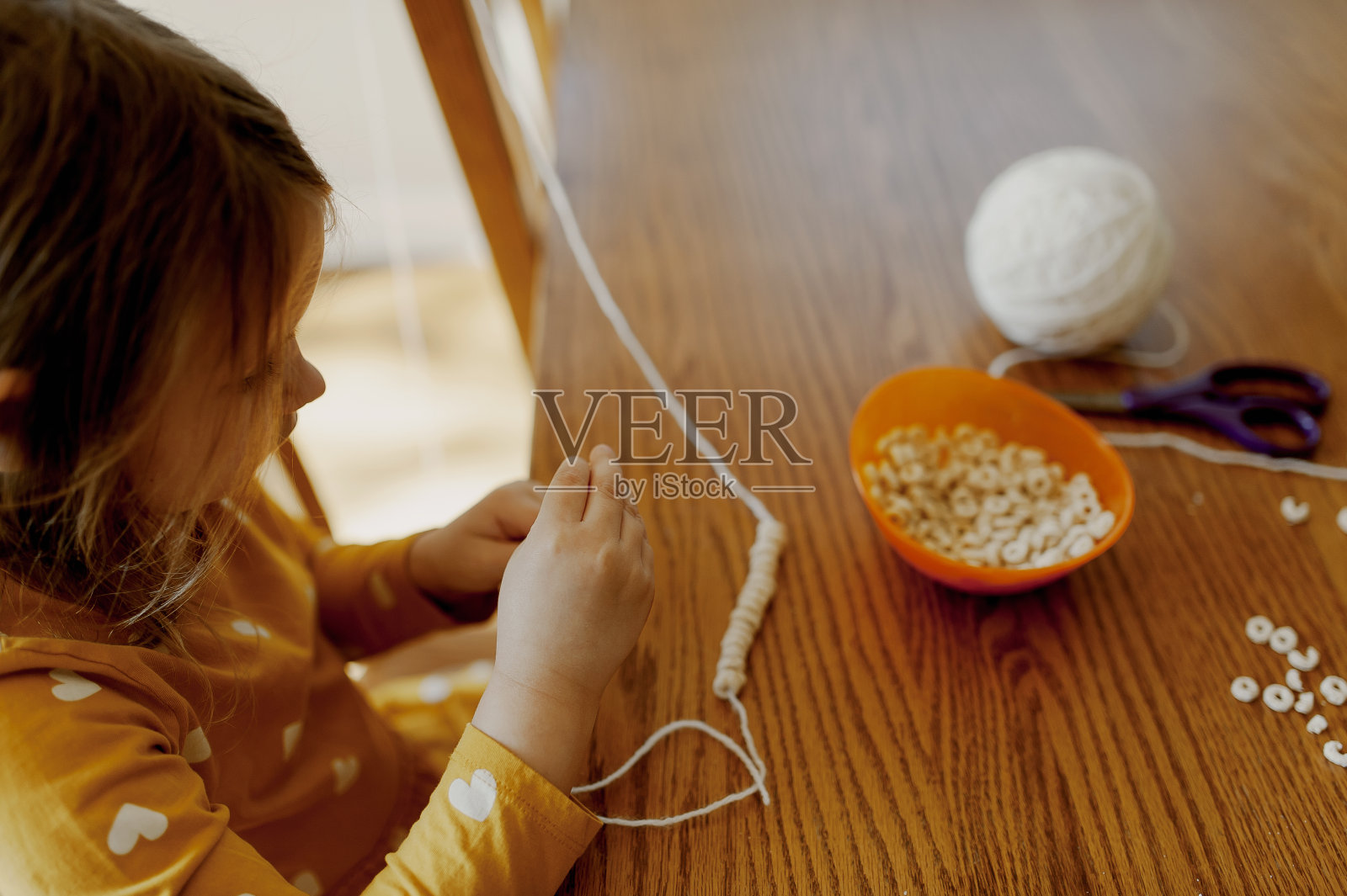 用谷物串成谷物项链或花环的小女孩照片摄影图片