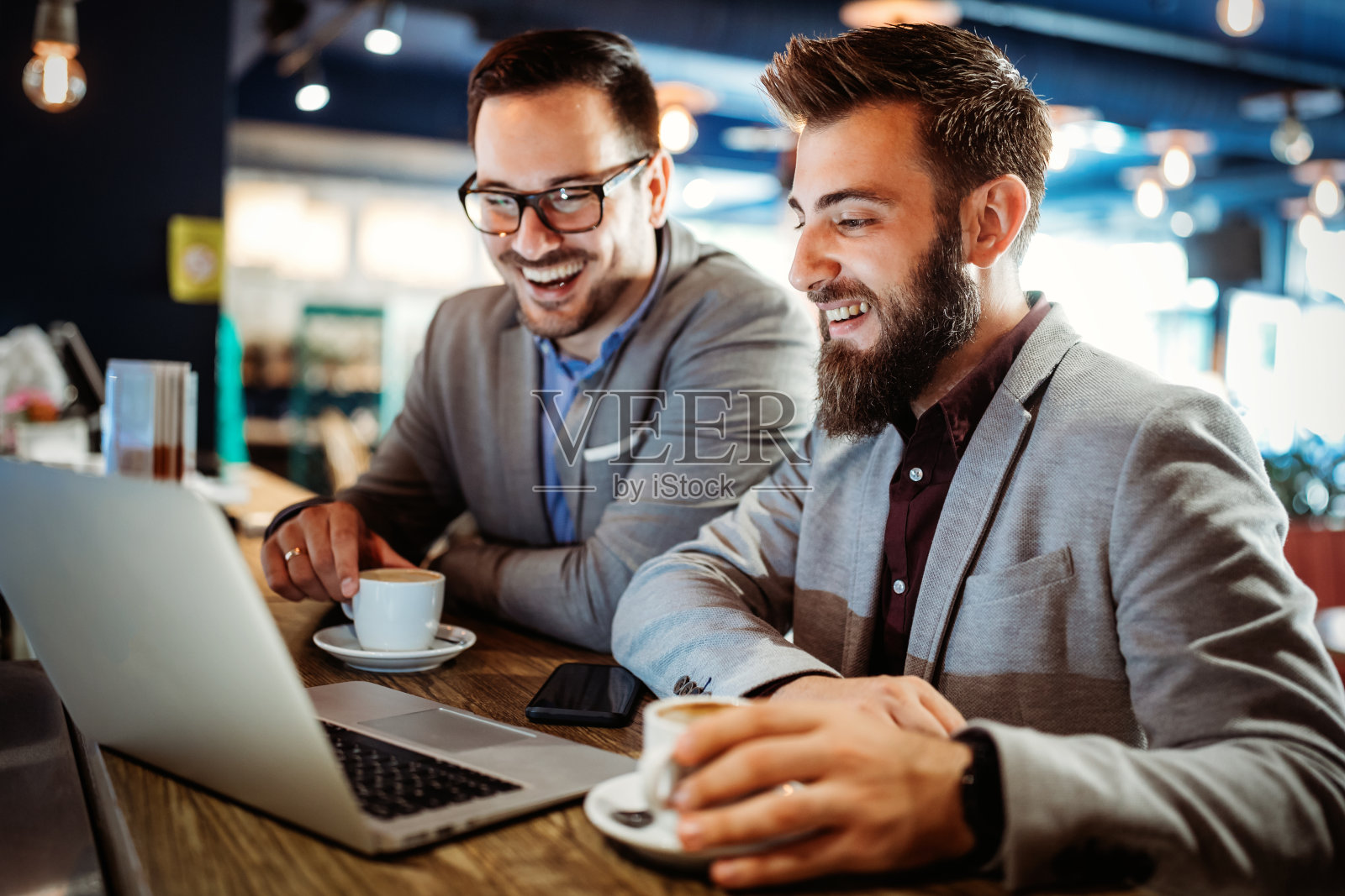 一组有吸引力的年轻商人同事在咖啡馆一起工作照片摄影图片