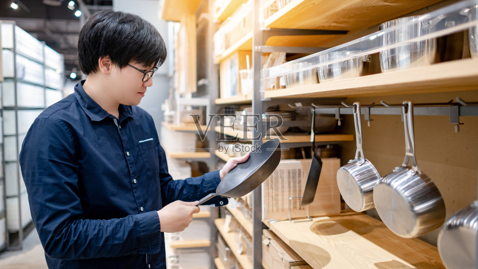 亚洲男子顾客在厨房用品店选择煎锅照片摄影图片