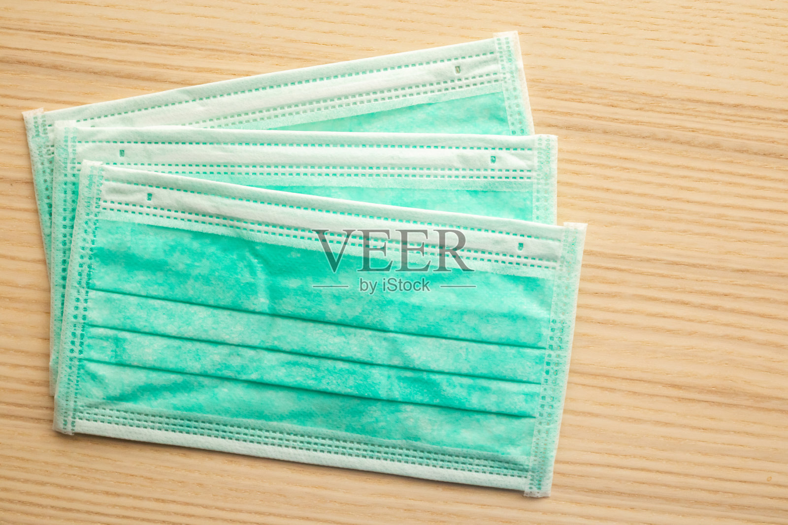 木质餐桌上的医用口罩,为covid-19冠状病毒感染的预防提供理念照片摄影图片