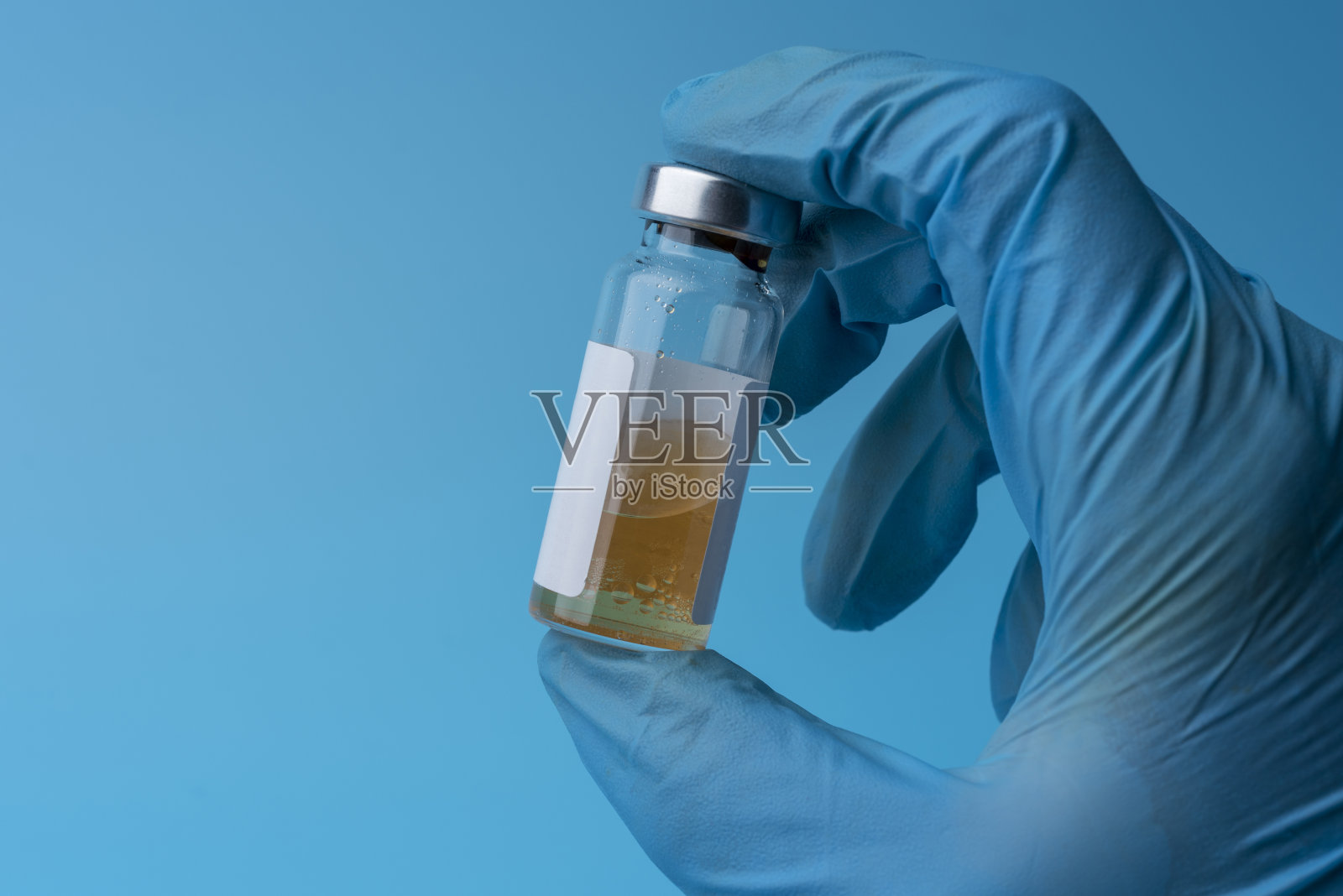 手拿医用手套拿药瓶。照片摄影图片