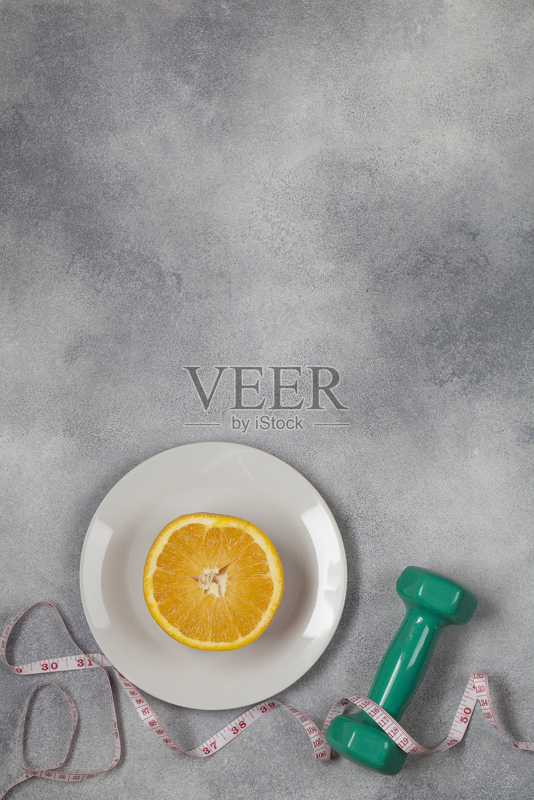 带尺寸的绿色哑铃和蓝色背景上的橙色切割板照片摄影图片