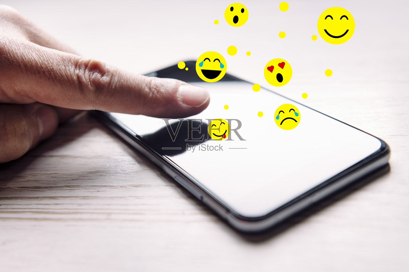 手指碰一下手机,表情符号就出来了照片摄影图片