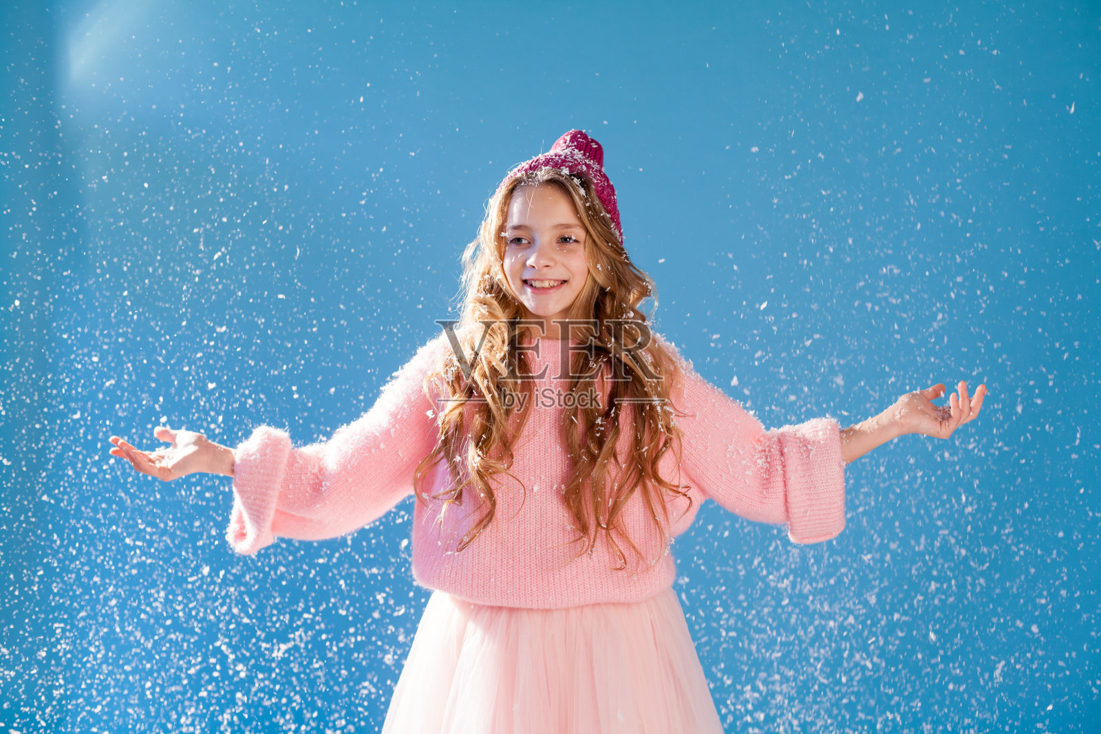 一个漂亮的时尚女孩的肖像,戴着冬天的帽子从寒冷和雪照片摄影图片