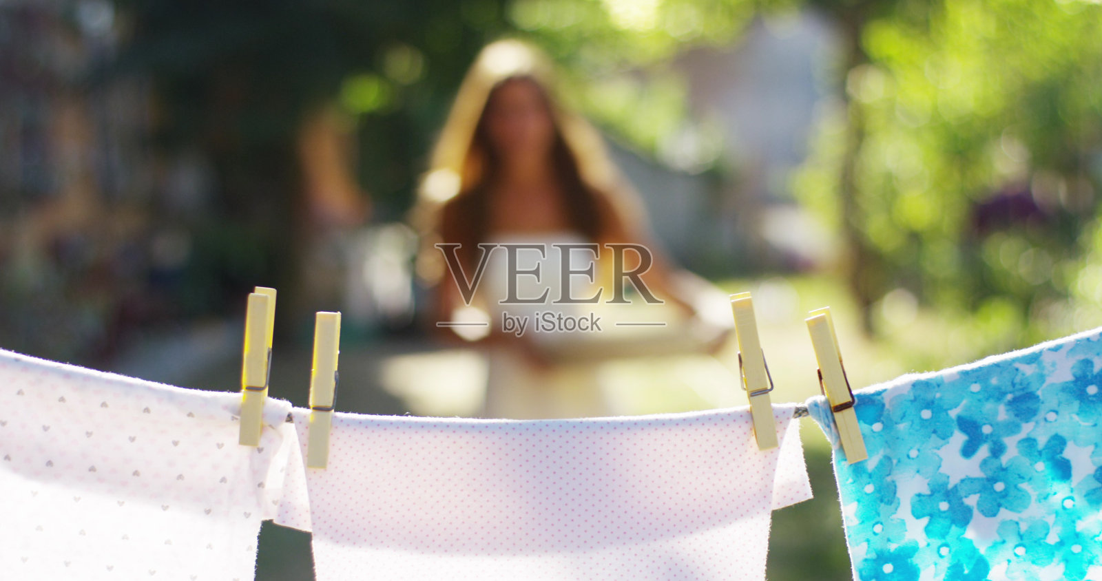 一名年轻女子为她的孩子晾衣服。衣服有香味而且干净。照片摄影图片