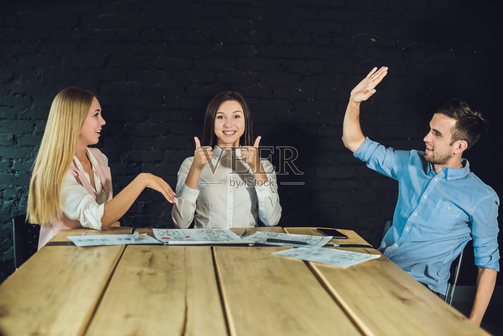 年轻的团队的同事观看故事板拍摄的视频在现代共同工作的办公室。团队合作的过程。水平,模糊的背景照片摄影图片