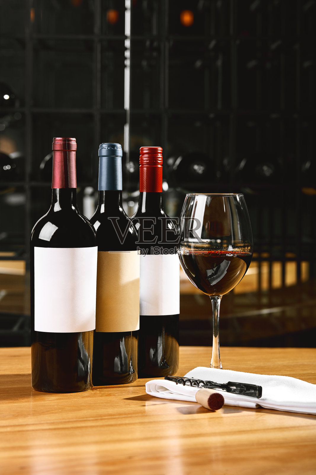 桌上放着一瓶葡萄酒和玻璃杯,背景是一杯葡萄酒。上酒,上酒。酿酒概念,复制空间照片摄影图片