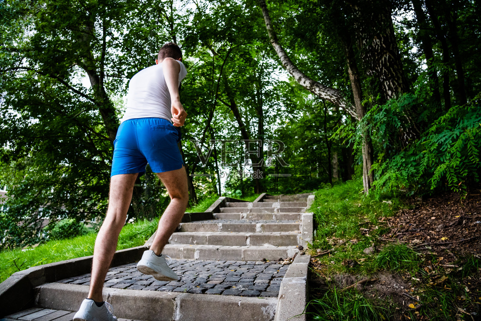 在公园楼梯上跑步的年轻人照片摄影图片