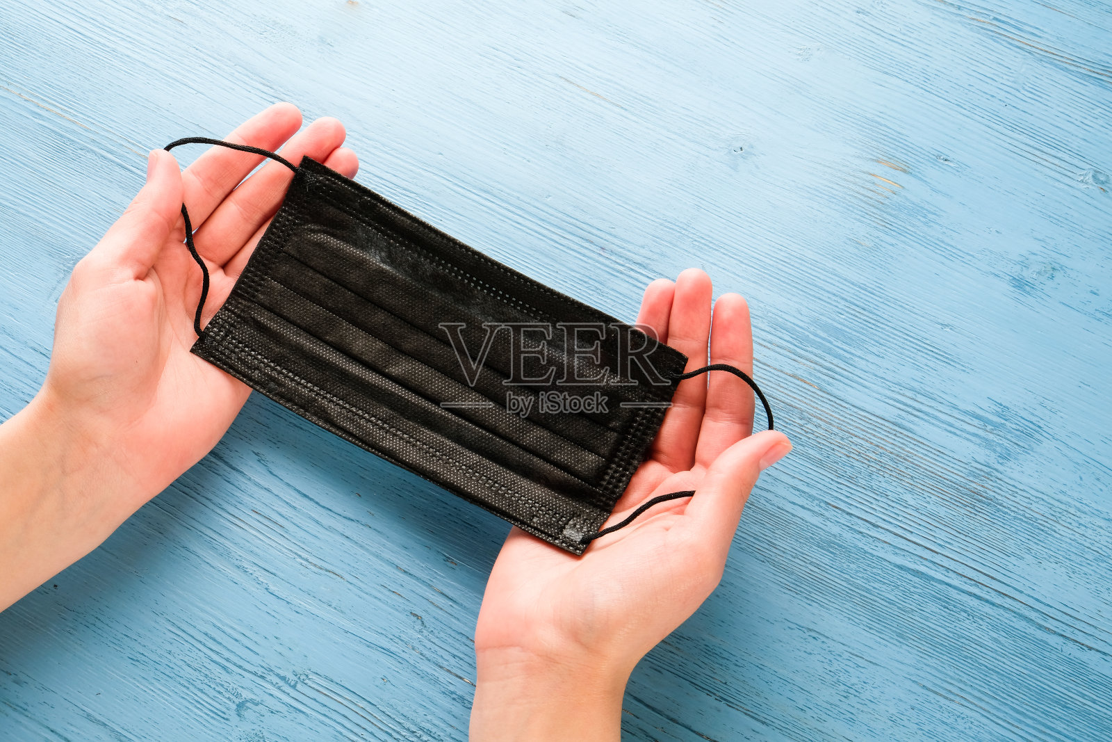 手戴医用口罩。照片摄影图片