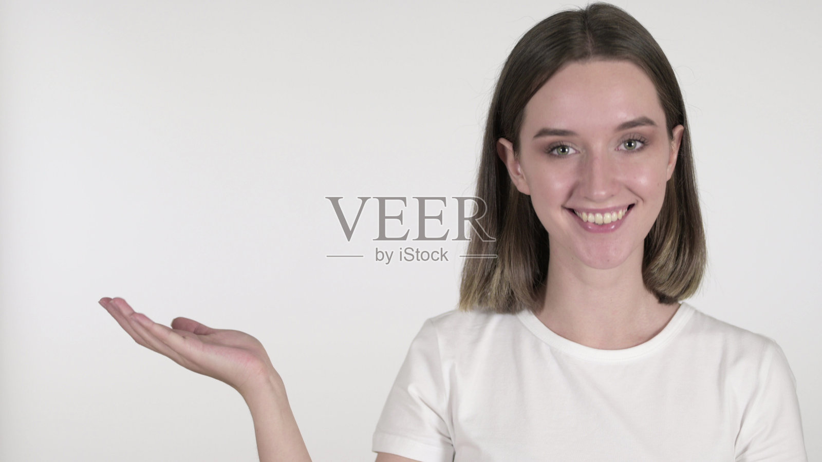 年轻女子展示产品与手,白色背景照片摄影图片