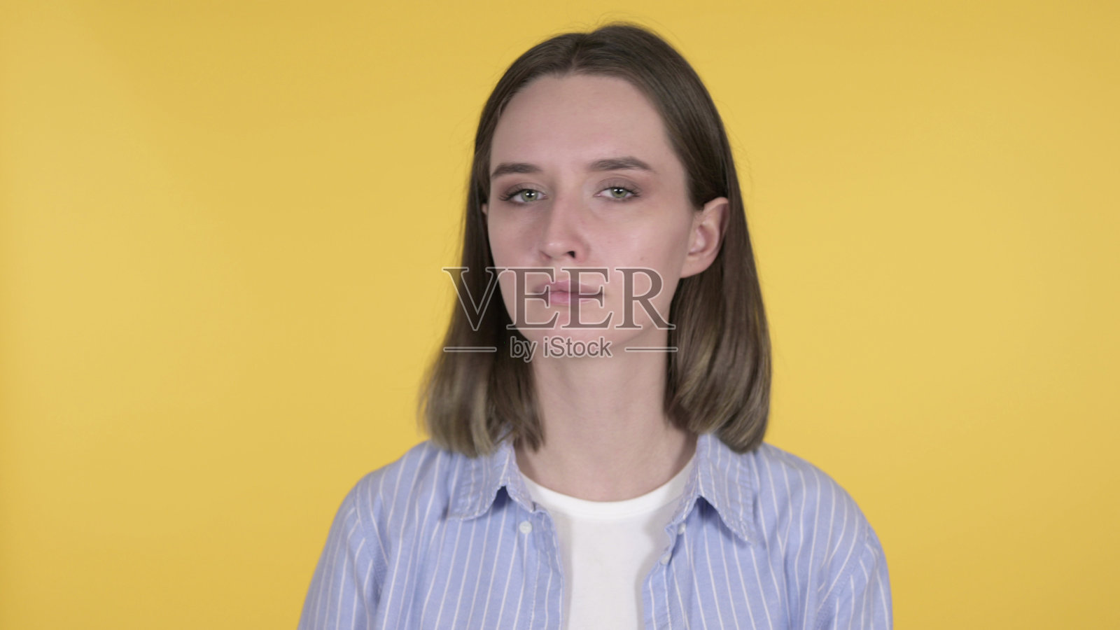 在黄色背景下,年轻女子摇头否认照片摄影图片