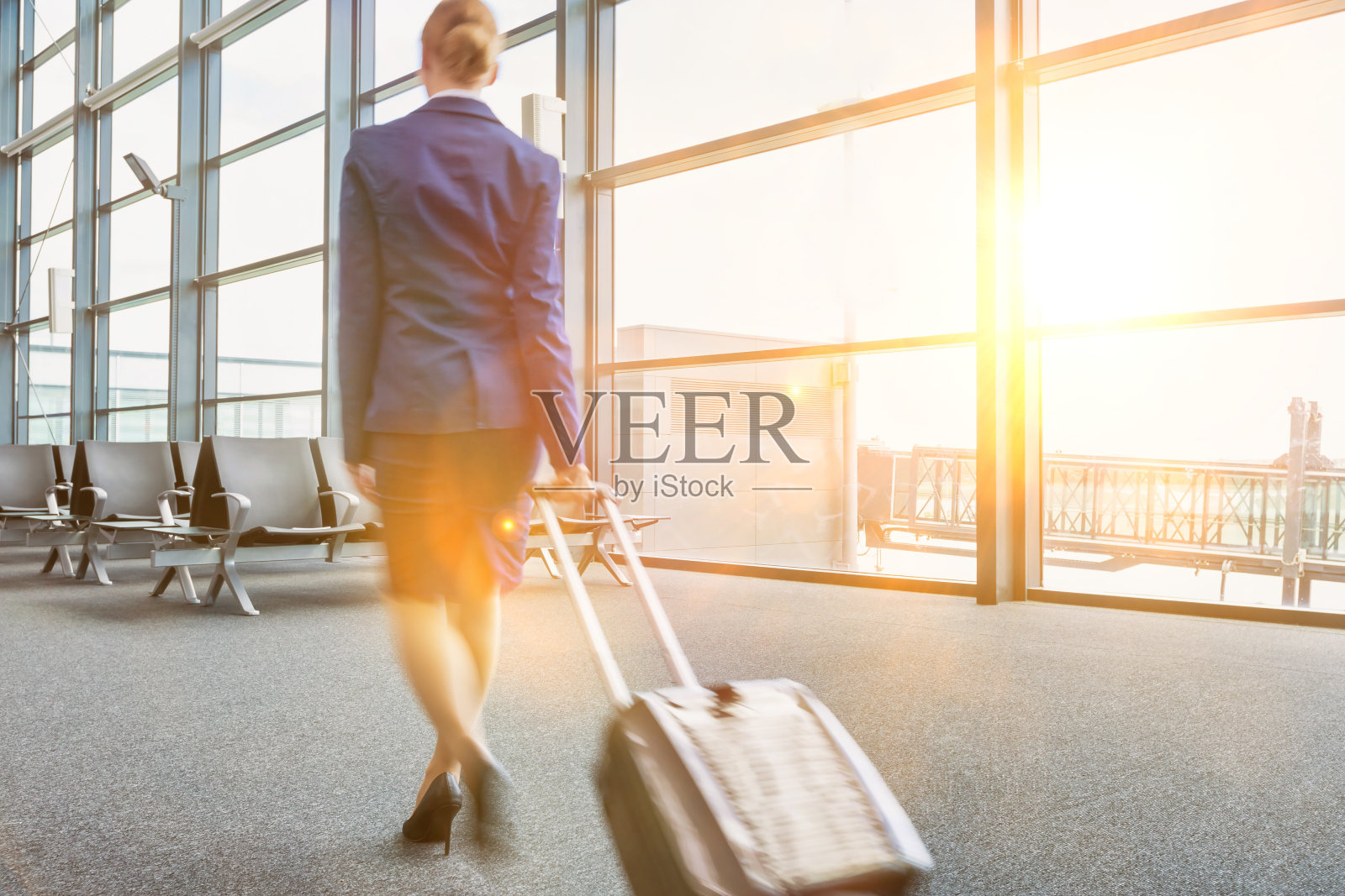 后视图的年轻空姐走在机场镜头光晕照片摄影图片