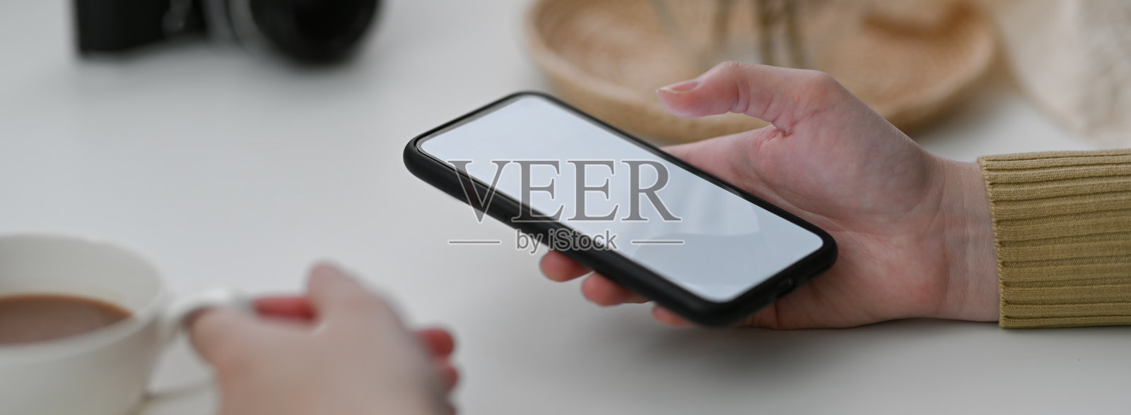 近距离观察女性自由职业者使用模拟智能手机联系客户和喝热咖啡照片摄影图片