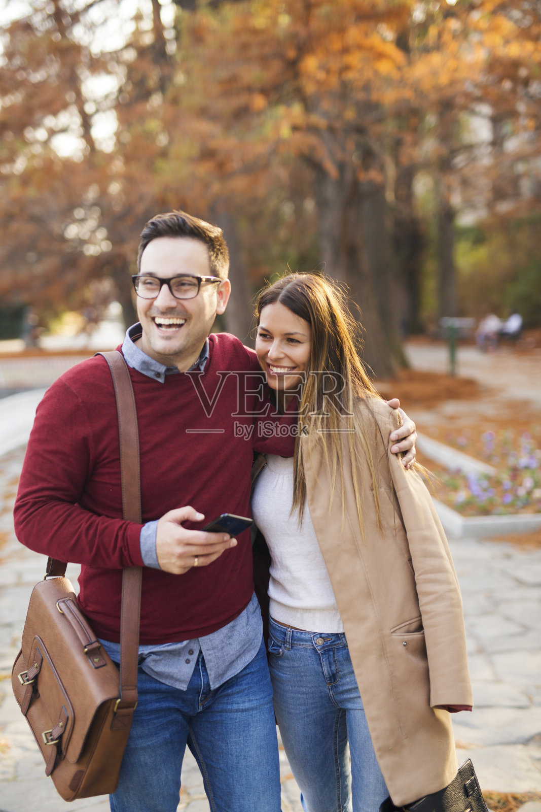 情侣们在公园里享受秋天。照片摄影图片