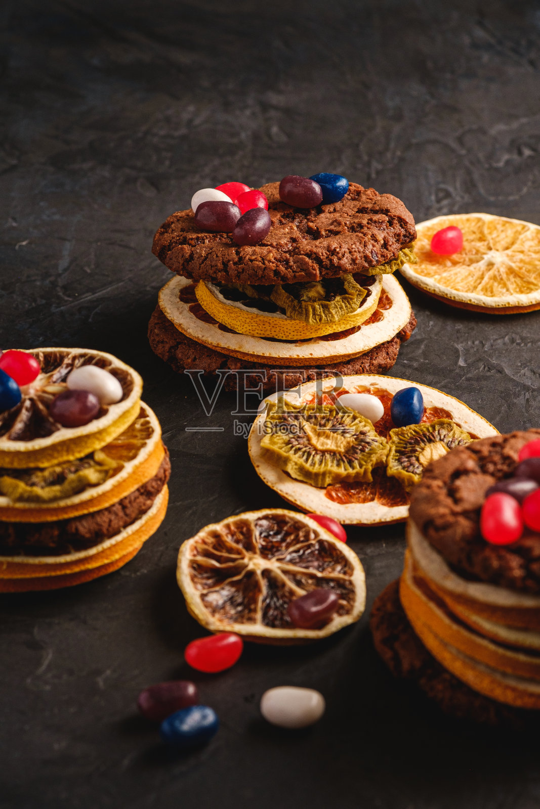 自制燕麦巧克力饼干三明治干柑橘水果和多汁果冻豆纹理黑色背景,角度视图照片摄影图片