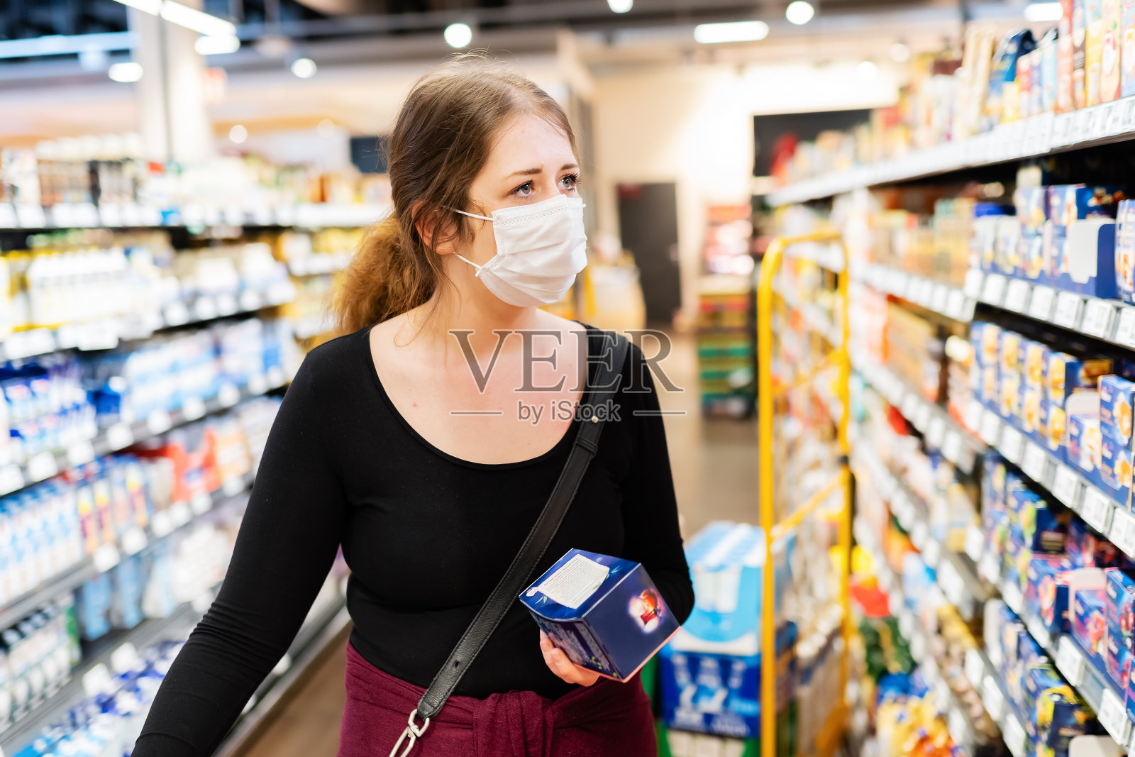 一名年轻女子在超市购物时戴着过滤面罩照片摄影图片